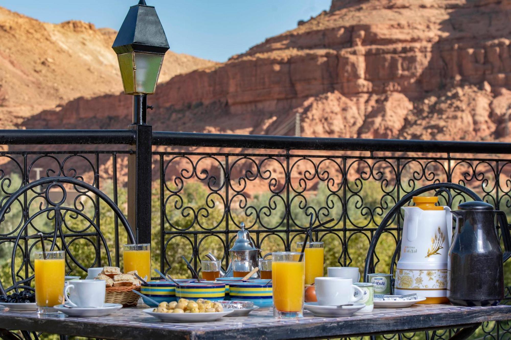 Moroccan lounge with rugs, cushions and a carved wooden arch at Hotel Awayou